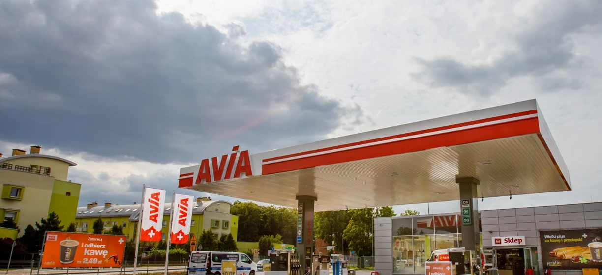 Reklama stacji paliw: Zatankuj i odbierz kawę za 2,49 zł w AVIA. Dodatkowo, skosztuj przekąsek w sklepie.
